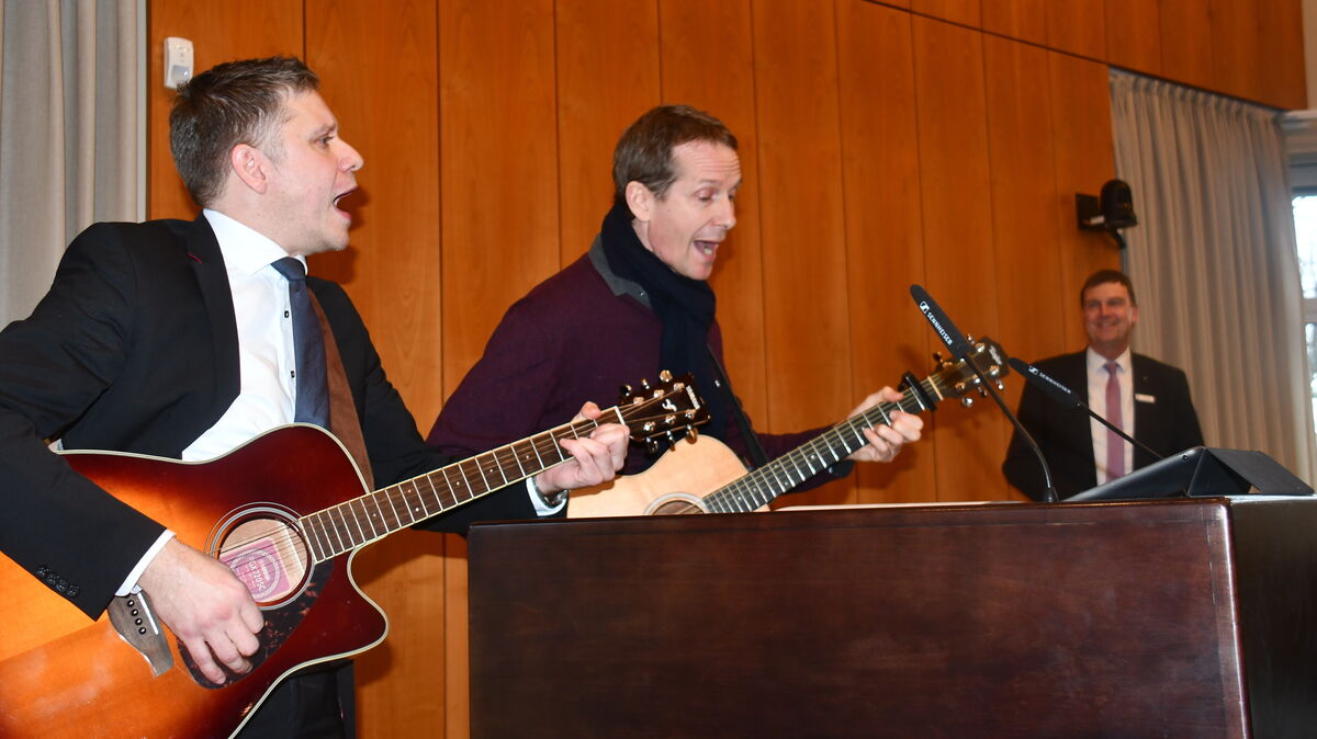 Dezernent Michael Take (l.) und der Grünen-Kreistagsabgeordnete Pacal Gentner hatten für die letzte Kreistagssitzung von Landrat Kai-Uwe Bielefeld (r.) die Gitarren ausgepackt und präsentierten eine auf ihn maßgeschneiderte Version eines Klassikers von Udo Jürgens ("Mit 68 Jahren..."). Foto: Schröder