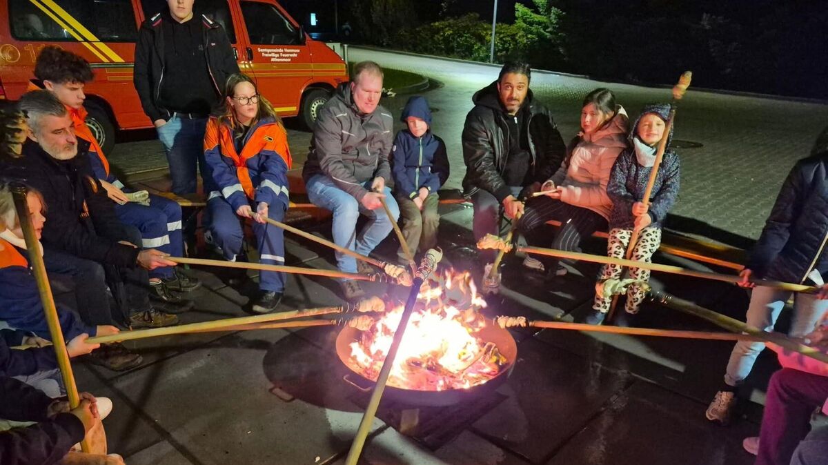 Nach dem Laternenumzug der Feuerwehren Westersode und Althemmoor sitzen Kinder und Erwachsene am Lagerfeuer und backen Stockbrot. Foto: Lange