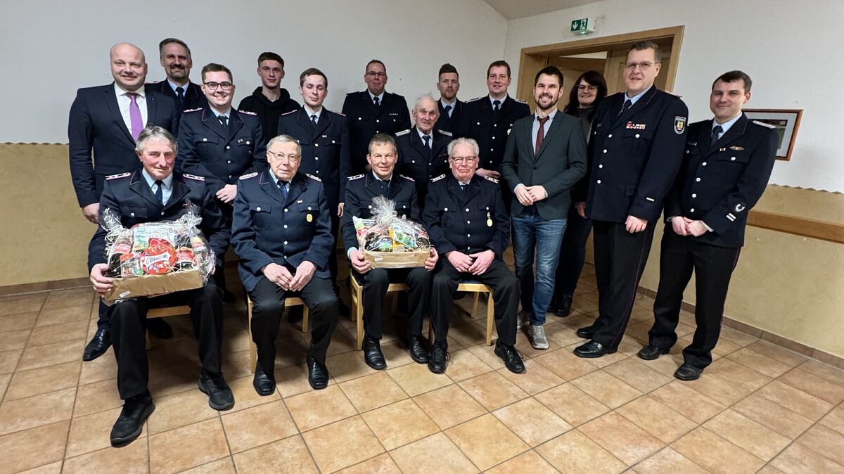 Gäste und geehrte Feuerwehrmänner kommen für das Gruppenbild zusammen.
