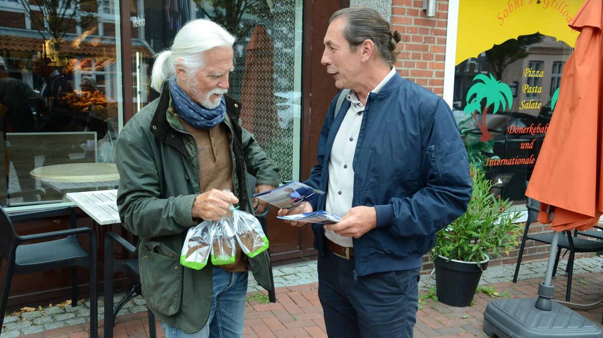 Samtgemeindebürgermeister Frank Thielebeule überreicht einem Einwohner in der Otterndorfer Altstadt einen seiner Flyer zur Wahl am kommenden Sonntag. Foto: Rohde