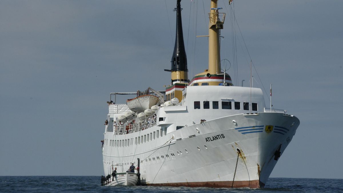 Die "Atlantis" vor Helgoland auf Reede, an Steuerbord eines der traditionellen Börteboote der Insel Helgoland, beim sogenannten "Ausbooten" der Fahrgäste. Archivfoto: Kramp
