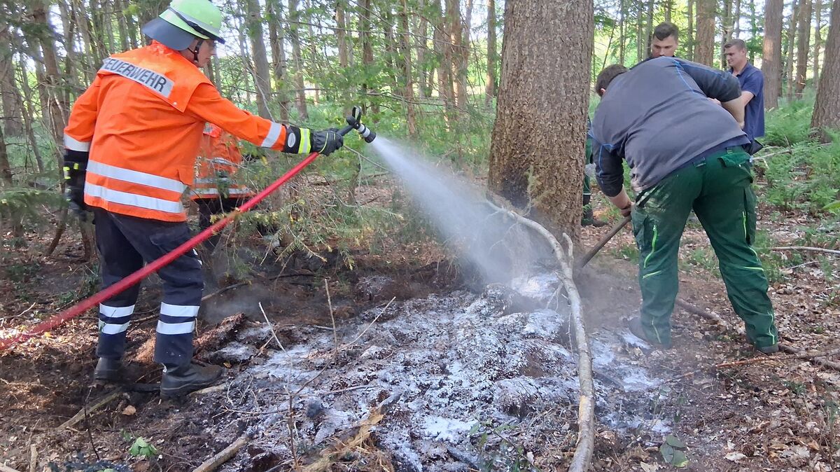Nachdem der Boden aufgelockert ist, werden die Brandstellen mit Netzwasser abgekühlt und endgültig gelöscht. Foto: Lange