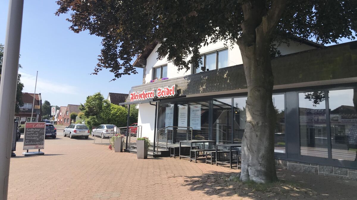 Vertraute Ansicht im Altenwalder Ortskern: Werbetafel und Außenbänke vor der Fleischerei Seidel. Unter dem Schriftzug die drei großen Plakate, die am Sonnabend urplötzlich über die Schließung am selben Tag informierten. Fotos: Reese-Winne