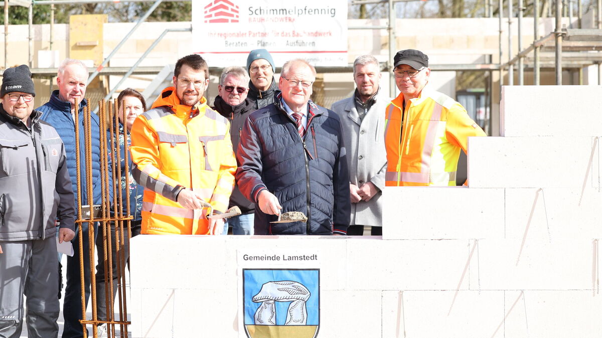 Mit Maurerkelle ausgestattet, lassen Samtgemeindebürgermeister Frank Springer (4. v. l.) und Lamstedts Bürgermeister Manfred Knust (3. v. r.) die Zeitkapsel im Fundament verschwinden. Foto: Larschow