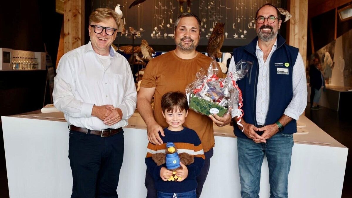Baudezernent Andreas Eickmann (l.) und Watt-BZ-Leiter Bernhard Rauhut (r.) beglückwünschen die Familie Edelin. Papa Alexander und Sohn Markus freuen sich über einen Präsentkorb und das Kuscheltier "Ranger Jan". Foto: Stadt Cuxhaven