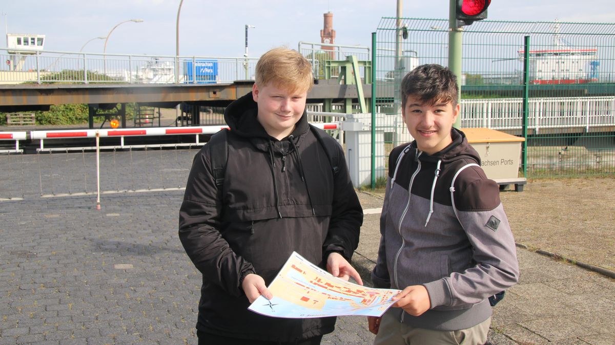 Die Schüler Maxim Saltsin und Maliak Barho informieren sich vor der Seeschleuse beim Neuen Fischereihafen über deren Funktionsweise. Foto: Potschka