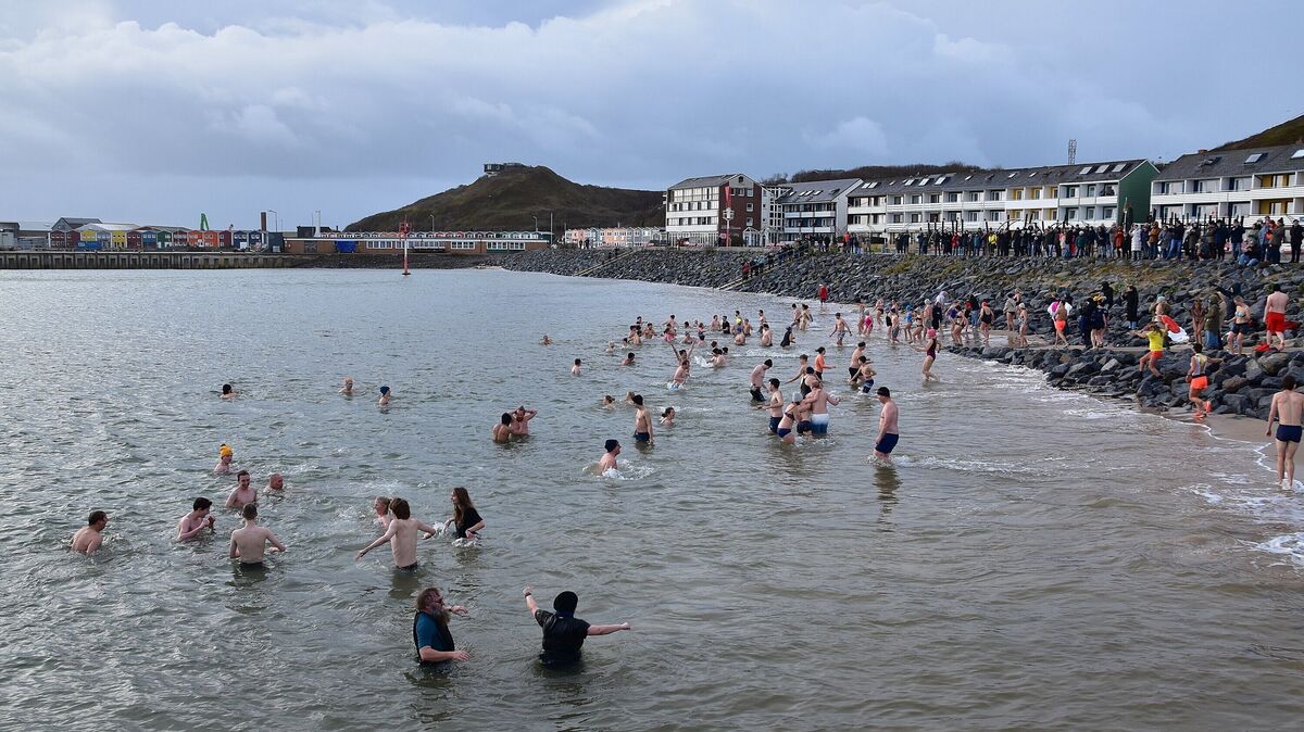 Anbaden an Neujahr auf Helgoland: Unter ruhigeren Bedingungen wagten sich zahlreiche Teilnehmer ins Wasser. Das für Sonntag geplante Eisbaden wurde dagegen wegen starker Winde abgesagt. Foto: Rauch