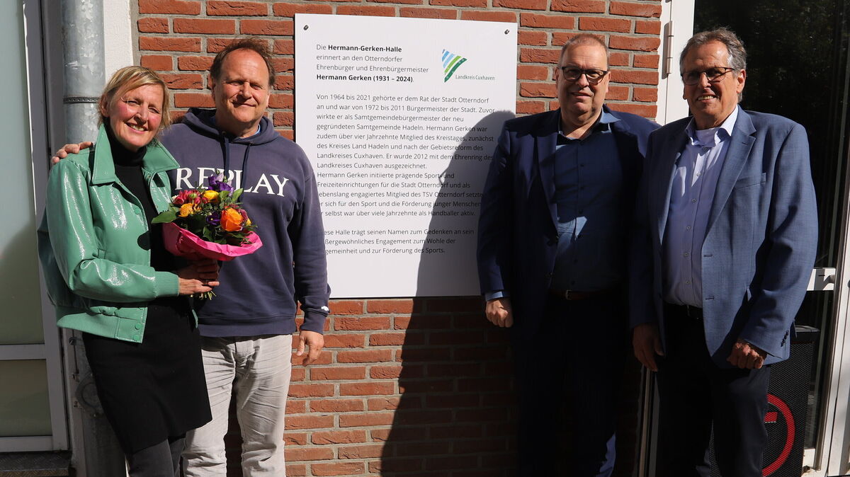 Nach der feierlichen Enthüllung der Erinnerungstafel neben dem Eingang der großen Sporthalle in Otterndorf freuten sich Marei Gerken, Jan Gerken, Landrat Thorsten Krüger und der Otterndorfer Bürgermeister Claus Johannßen (von links) über eine gelungene Zeremonie bei Kaiserwetter. Foto: Witthohn