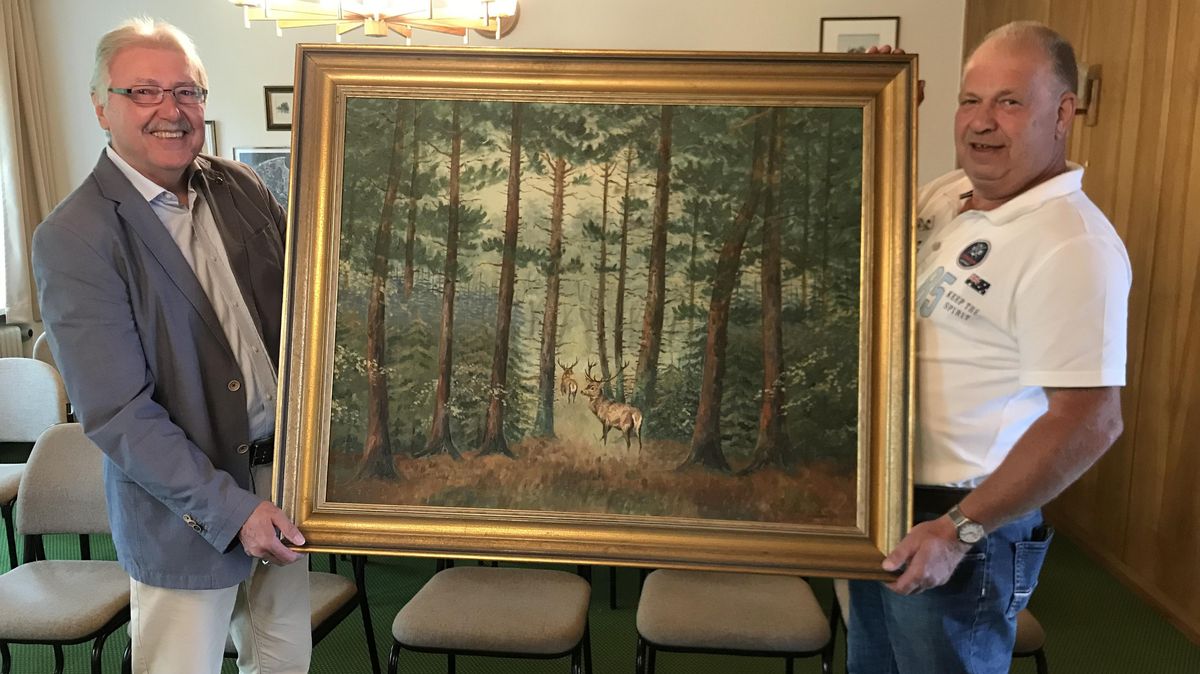 Ein ganz schöner Schinken ist es schon, aber einer mit Bezug zu Altenwalde - und wenn es nur durch den Heidemaler Alex Kirchhof ist: Ingo Grahmann (l.) und Axel Zeuner freuen sich, dass das Bild aus dem Hause Zeuner in die Sammlung des Ortsrats gefunden hat. Foto: Reese-Winne