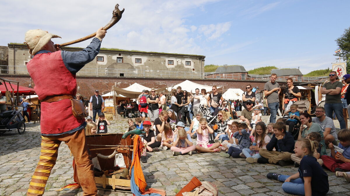 Der "Kiepenkasper" ruft zur Vorstellung: Im Rund von Fort Kugelbake scharen sich schon am Eröffnungstag des 26. Historienspektakels zahlreiche Kinder um den Puppenspieler. Die Veranstaltung läuft noch bis einschließlich Sonnabend. Foto: Koppe
