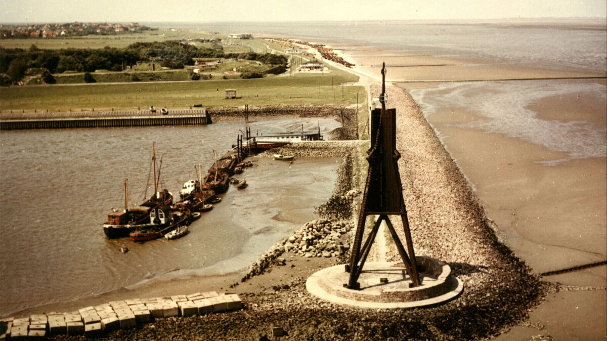Blick auf die Kugelbake mit Bauhafen, wie er sich in den 1950er und 1960er Jahren darbot. Es gab hier einen beachtlich langen Anlegesteg. Im Hintergrund ist vor dem Fort Kugelbake noch die alte Strandhalle zu erkennen. Foto: Stadtarchiv