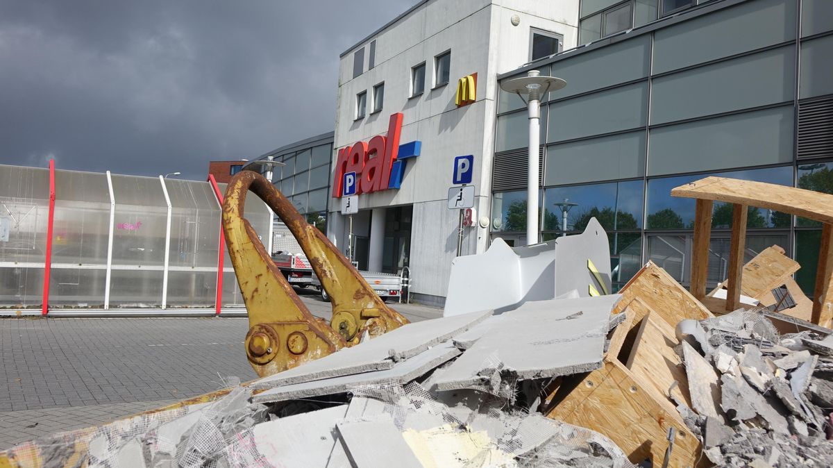 Container voller Bauschutt. Viele Abrisshelfer die einen Eimer und eine Karre nach der anderen aus dem Real-Markt heraus tragen. Das ist das aktuelle Bild vor dem Real-Markt in Cuxhaven. Überraschend für einige Kunden schloss der Markt bereits vor dem Monatsende. Foto: Anders
