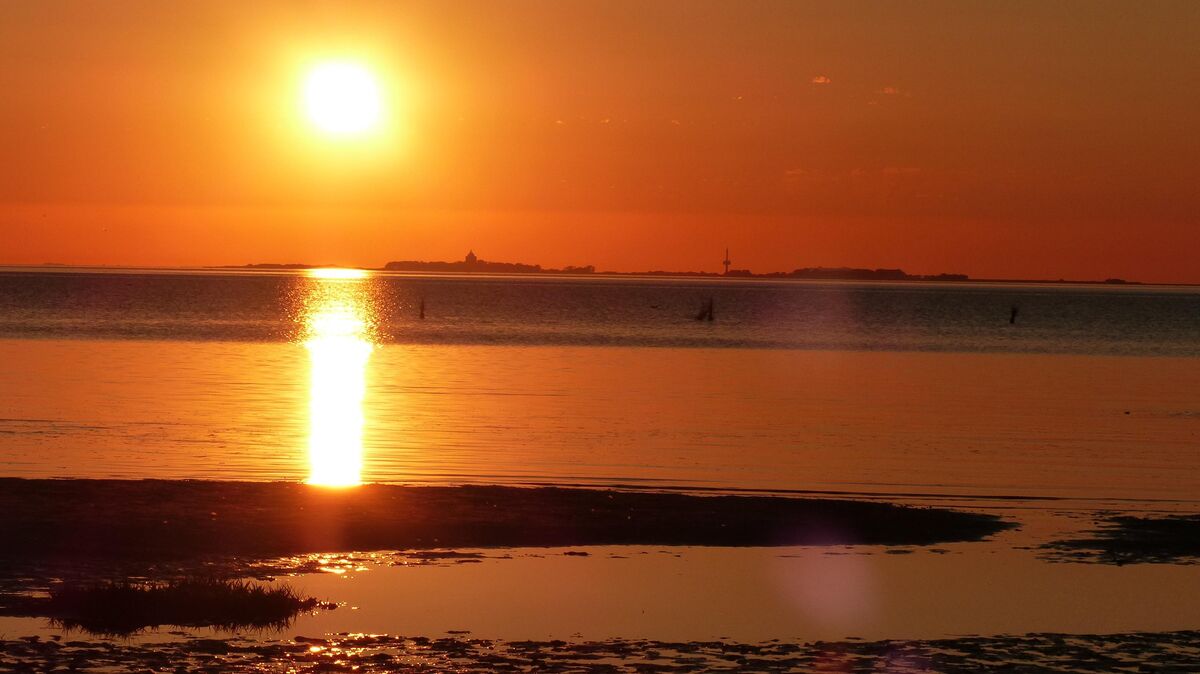 Sonnenuntergang am Strand. Sahlenburg im abendlichen Zauberlicht mit Neuwerk am Horiziont. Foto: Reese-Winne