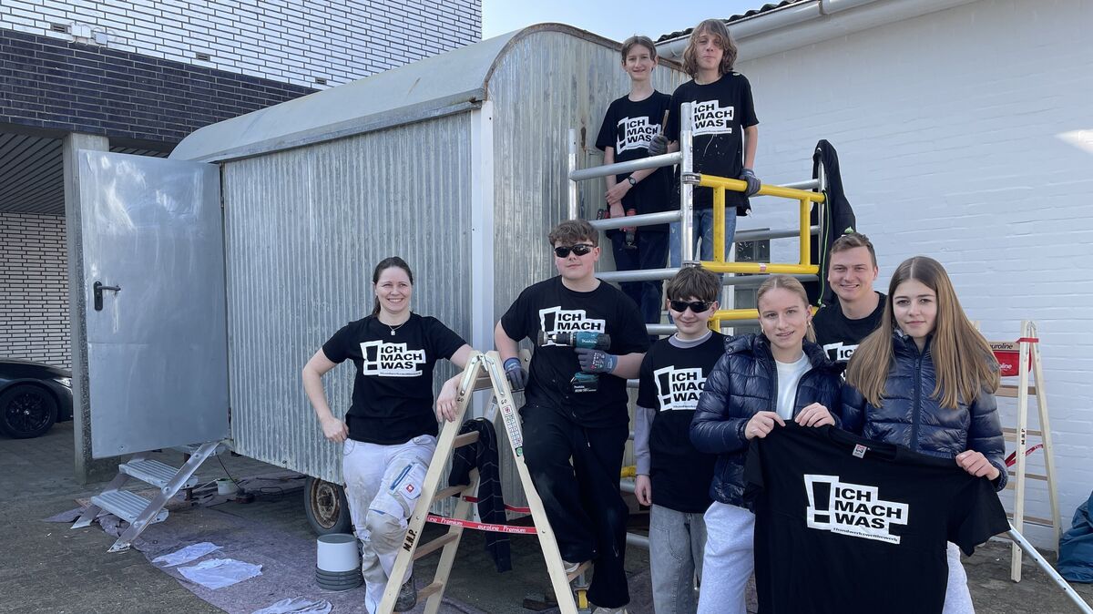 Sie schwingen gemeinsam die Werkzeuge für den Bauwagen im Schulgarten: links Corinna Ostheim, Gesellin der Firma Peycke, 2. von rechts Lehrer Martin Kliebe. Foto: Reese-Winne
