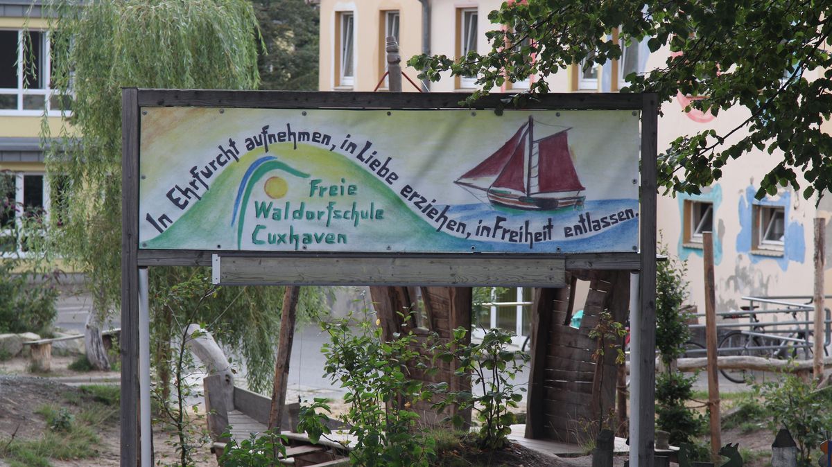 Blick auf den mit Holz-Spielgeräten und viel Grün gestalteten Schulhof. Das gemalte Schild mit dem Leitsatz "In Ehrfurcht aufnehmen, in Liebe erziehen, in Freiheit entlassen" ziert auch das Schul-Schiff "Freiheit". Fotos: Reese-Winne