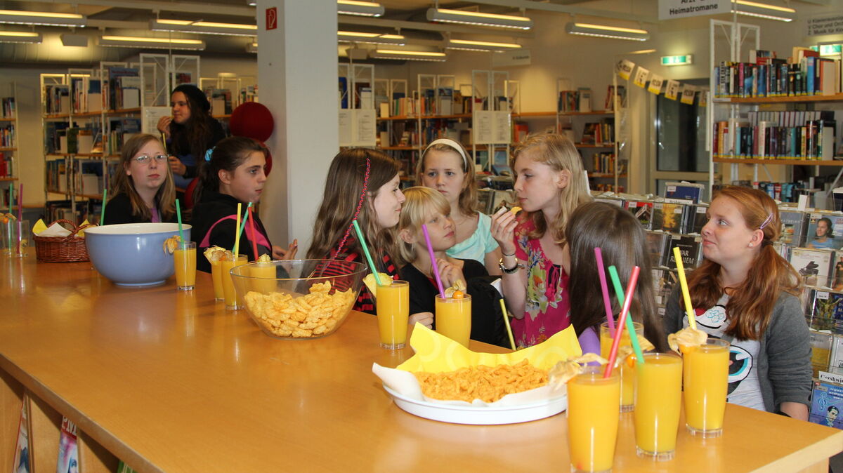 Erinnerungen an die Abschlussparty im vergangenen Jahr: Schülerinnen und Schüler genießen Snacks und Getränke während des 19. Sommerleseclubs in der Stadtbibliothek Cuxhaven. Foto: Reese-Winne