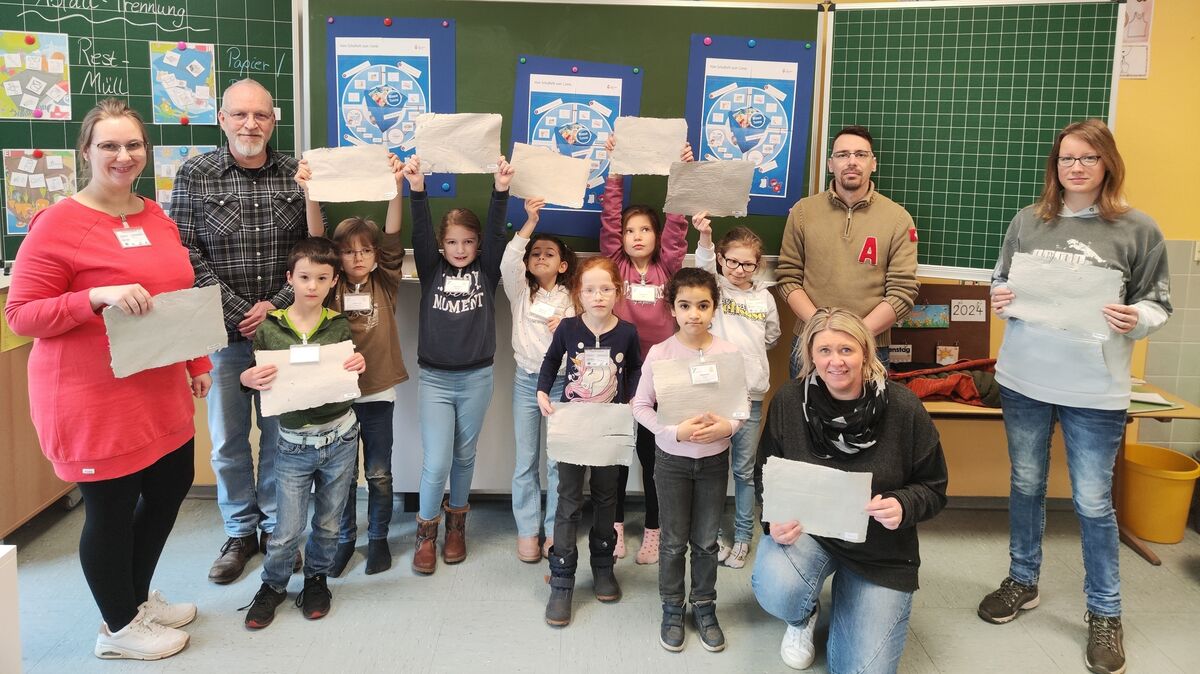 Die Schüler der Klasse 2b freuen sich mit ihren Lehrereinnen und den Abfallberatern des Landkreises über ihr selbstgeschöpftes Papier. Foto: privat