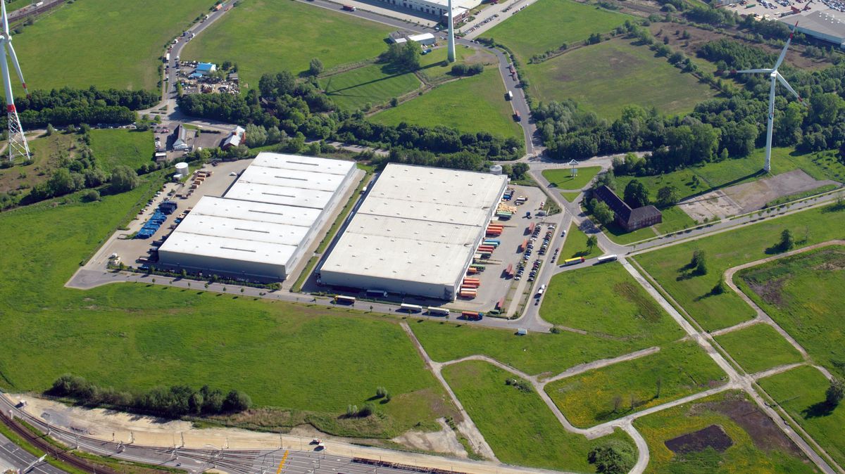 Drei große Lagerhallen stehen auf dem ehemaligen Gelände Carl-Schurz-Kaserne am Amerikaring (kleines Bild). Die beiden kleineren sind vermietet, in die große Halle (rechts) zieht zum Jahres ende Amazon mit einem neuen Vertriebszentrum ein. Archiv-Foto: Scheer