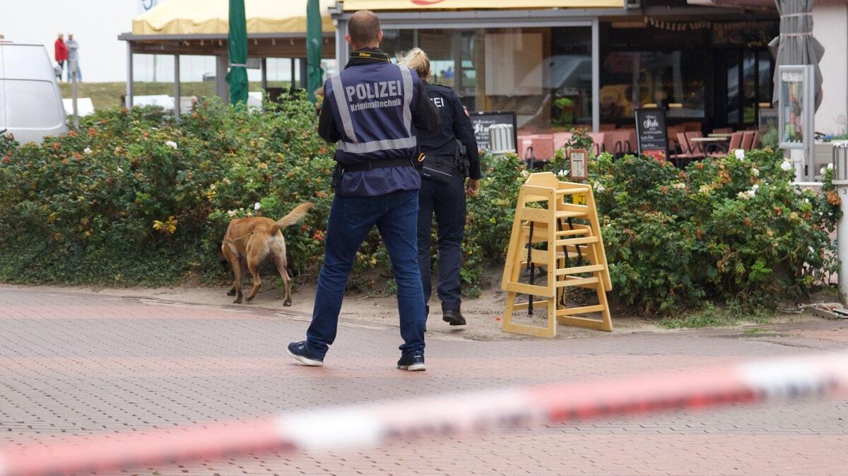 Mit einem Spürhund sucht die Polizei am Donnerstag nach der Tatwaffe - mit: Ein Messer wird ebenso in unmittelbarer Nähe zum Tatort gefunden wie ein Fluchtauto. Foto: Koppe