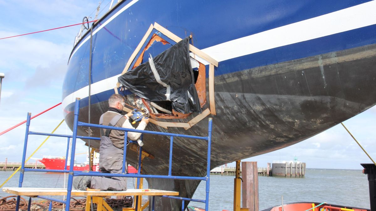 Eigner Cezary Wolski repariert das große Loch im Rumpf notdürftig. Es entstand, als die Yacht in der Nacht vom 11. auf den 12. August gegen eine Fahrwassertonne auf der Außenelbe gekracht ist. Foto: Sassen