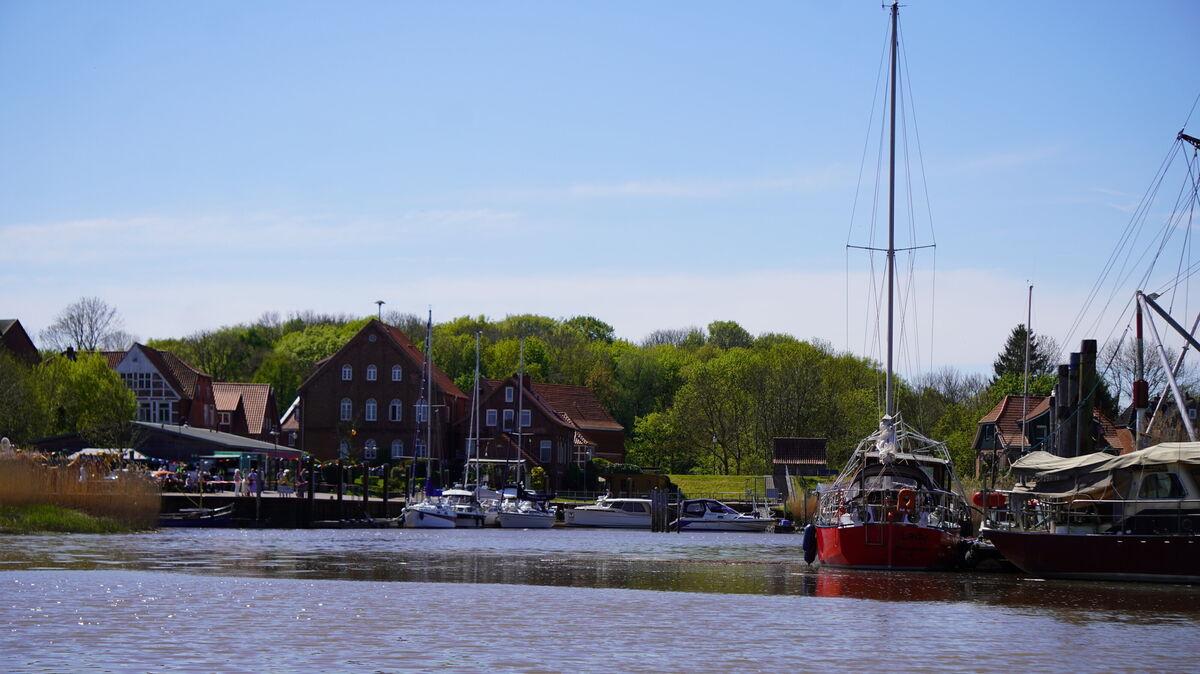 Strahlender Sonnenschein am historischen Hafen von Neuhaus: Besucherinnen und Besucher genießen das Bärbel-Fest mit Blick auf die malerische Kulisse der Oste. Foto: Brettschneider