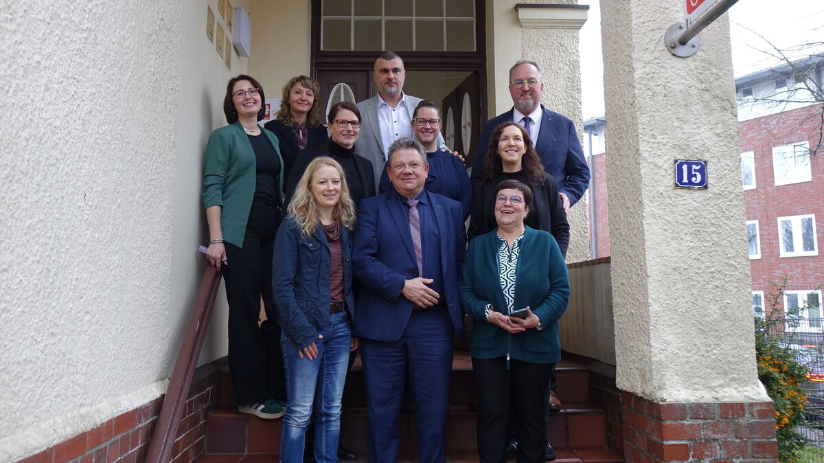 Kamen für einen Austausch bei der Caritas Cuxhaven zusammen: (dritte Reihe v.l.) Yuliya Kamp, Larisa Müller, Waseem Aleed, Uwe Santjer, (zweite Reihe v.l.) Dr. Charlotte Freund, Christina Laabs, Ina Tiedemann, (vorne) Kerstin Wehmeier, Minister Dr. Andreas Philippi, Sabine Tiedemann. Foto: Märthe Werder
