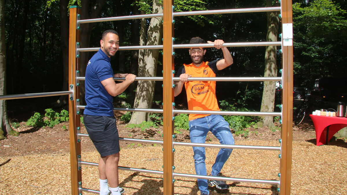 Henry Mordi und Mazin Darwesh testen die Kletterstangen des neuen Trimm-Dich-Pfads im Wernerwald bei der Eröffnung. Foto: Potschka