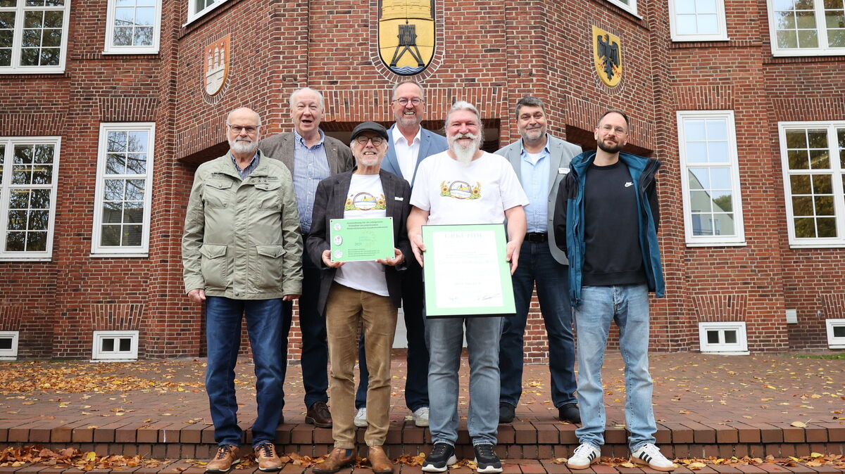 Die Mitglieder des Kleingartenvereins Döse-Nord präsentieren stolz ihre Auszeichnungen vor dem Cuxhavener Rathaus nach dem Gewinn des Landeswettbewerbs in Niedersachsen. Foto: Larschow