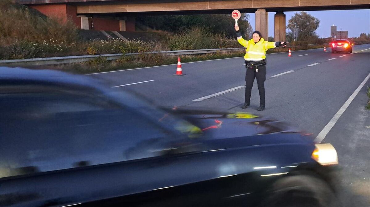 Großkontrolle hinter dem Wesertunnel: Eine Polizeibeamtin hält einen Autofahrer an. Foto: Iven
