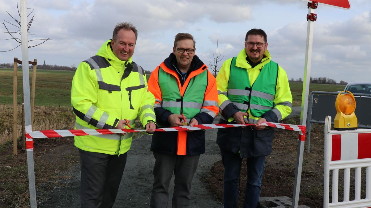 Mit einem symbolischen Banddurchschnitt gaben Oberbürgermeister Uwe Santjer, Claus-Heinrich Behrens, Vorsitzender des Bürgervereins Köstersweg, und Lüdingworths Ortsbürgermeister Thomas Brunken (v.l.n.r.) den ersten Abschnitt des Fahrradwegs frei. Foto: Mangels