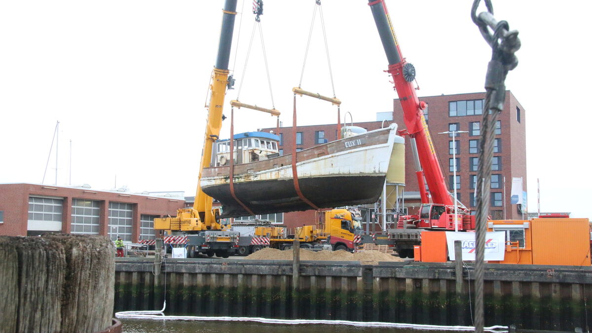 Die „Albatros“ schwebt zwischen Himmel und Wasser: Mit größter Präzision bergen zwei Kräne den 54-Tonnen-Kutter aus dem Ritzebüttler Schleusenpriel.