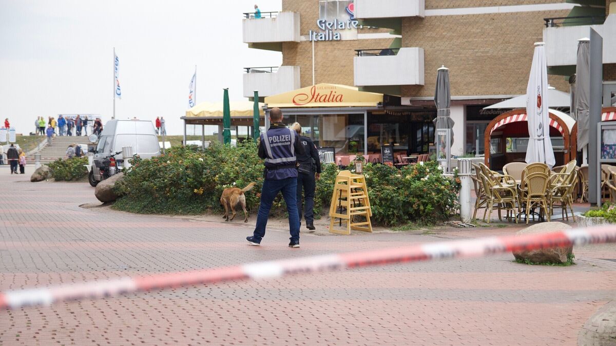 Das Bild zeigt das von der Polizei abgesperrte Umfeld des Tatorts: Mit einem Suchhund fahnden Beamte am Vormittag nach der Auseinandersetzung nach der Tatwaffe. Foto: Koppe