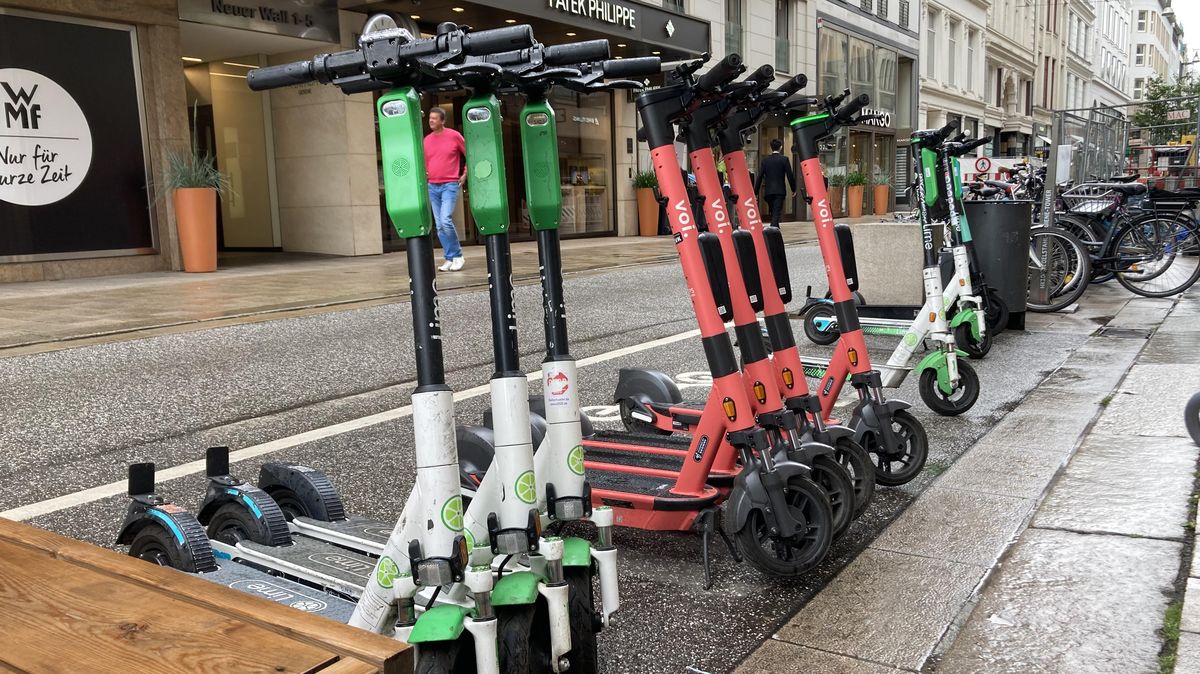 E-Scooter der Firma Limebike Germany GmbH (Bildvordergrund) an einer Verleihstation am Neuen Wall in Hamburg. Die weiß-grünen Gefährte, die mittlerweile das Bild vieler deutscher Großstädte prägen, könnten demnächst auch in Cuxhaven auftauchen. Der Eigentümer ist einer von zwei Verleihern, die sich vor Ort um eine Konzession bemühen. Foto: Koppe
