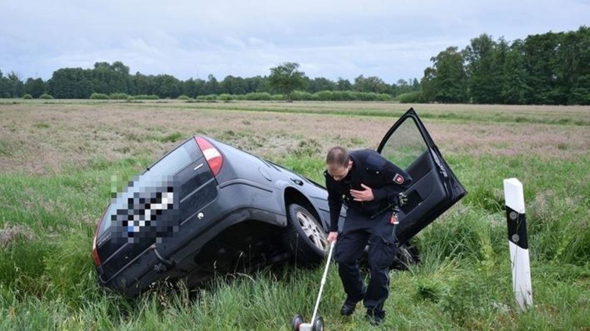 Nach der Rettung vermisst ein Polizist die Unfallstelle. Der Ford Mondeo Kombi war in einer Kurve von der Fahrbahn abgekommen. Foto: Vasel
