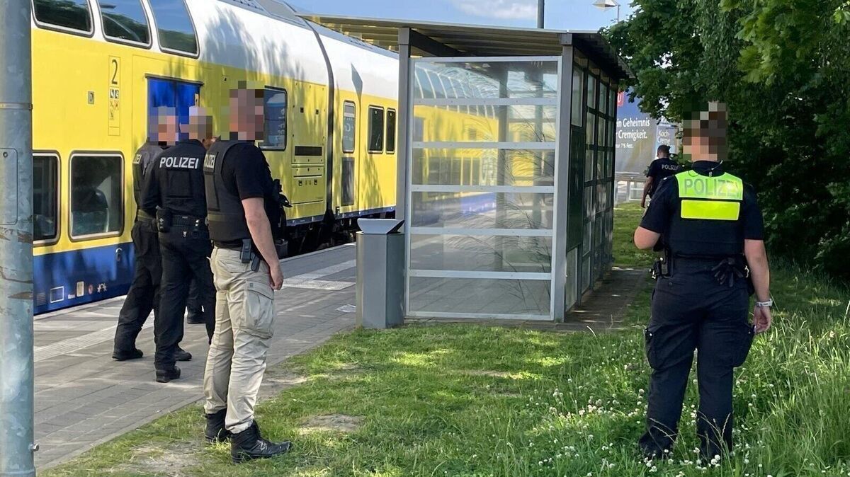 Beamte der Polizei und Bundespolizei suchen auf dem Grünstreifen neben Gleis 3 nach dem Messer. Foto: Lütt