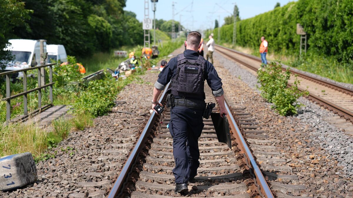 Polizisten gehen nach einem Brand an der Bahnstrecke zwischen Hamburg und Cuxhaven auf dem Gleis. Im niedersächsischen Neu Wulmstorf hat in der Nacht zu Dienstag ein Verteilerkasten gebrannt. Die beschädigten Signalleitungen legten den Zugverkehr zwischen Hamburg und Cuxhaven für Stunden lahm. Foto: Marcus Brandt / dpa-Bildfunk
