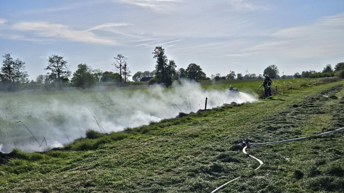 Unter schwerem Atemschutz beginnen zwei Trupps, mit drei Hohlstrahlrohren das Feuer zu löschen. Foto: Lange