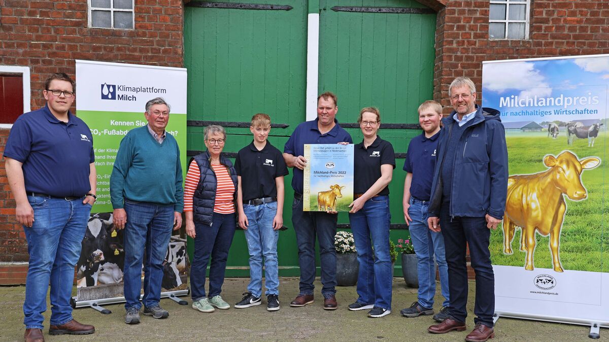 Jan Heusmann (Vorstand der Landesvereinigung der Milchwirtschaft Niedersachsen, r.) überreichte in Lamstedt das Hofschild an die Familie Damman und deren Team. Foto: Dierk Gieschen