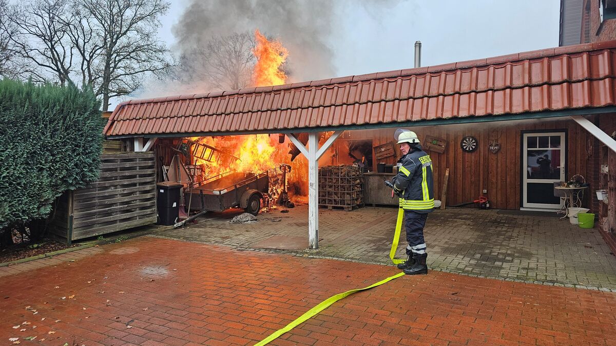 Beim Eintreffen der ersten Einsatzkräfte schlugen die Flammen bereits aus dem Dach des Carports. Aus dem Tanklöschfahrzeug heraus wurde umgehend der Löschangriff eingeleitet. Foto: Jürgen Lange