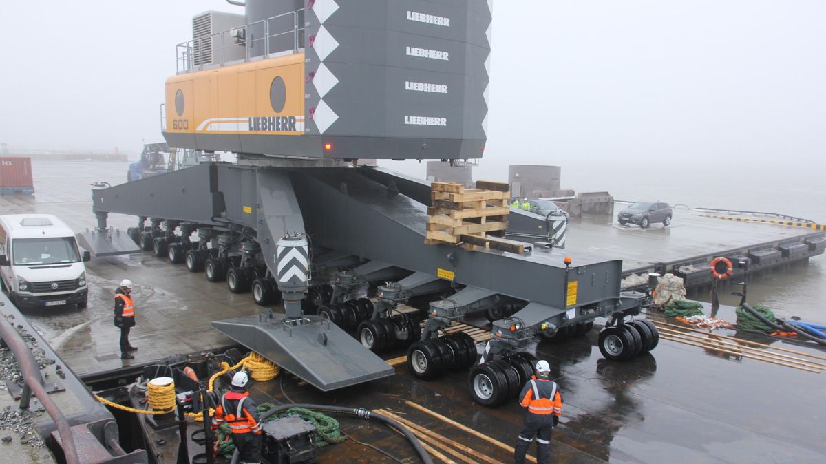Spannender Moment: Die drei letzten Achsen des 600 Tonnen schweren Mobilkrans rollen über Stahlplatten vom Ponton auf die Pier. Foto: Sassen