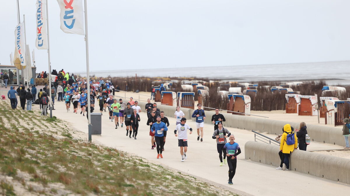 Läuferinnen und Läufer des Cuxhaven-Marathons genossen die neue Küstenstrecke entlang der Promenade, während sie an den Strandkörben vorbeizogen - die an diesem Tag weitestgehend unbesetzt blieben. Foto: May
