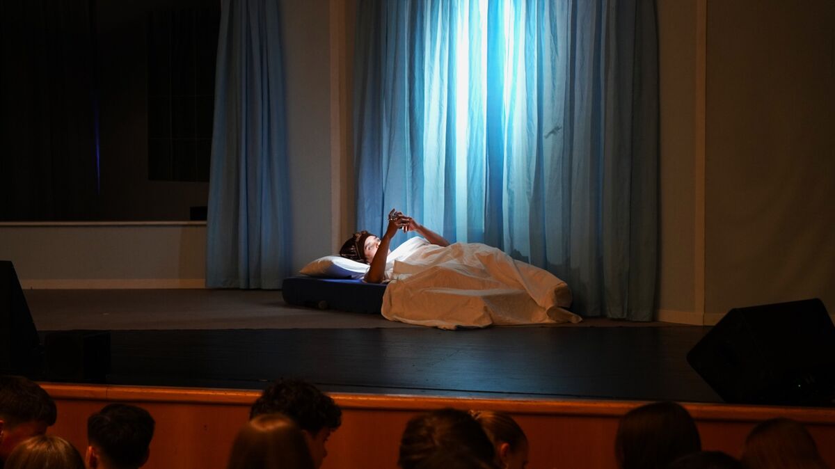 Hauptfigur des Theaterstücks, "Sieben Wege, Kylie Jenner zu töten", Cleo im blauen Licht ihres Smartphones. Das Stück behandelt Rassismus, Macht und Social Media. Foto: Brettschneider