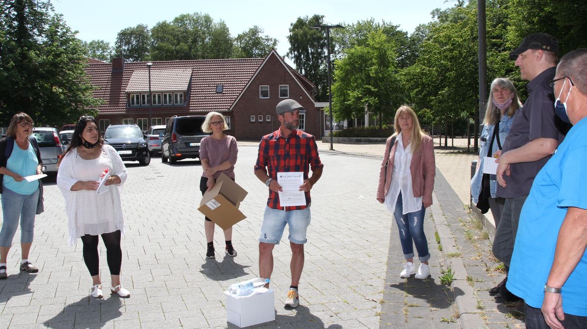 Treffen am Sonnabend auf dem Ritzebütteler Marktplatz und letzte Absprache: Wer verteilt in welchen Straßen? - Klingeln oder nicht? (Antwort: nein). - Auch an Beherbergungsbetriebe oder nur an Einheimische? (Antwort: nur an die Bevölkerung Cuxhavens). Foto: Reese-Winne