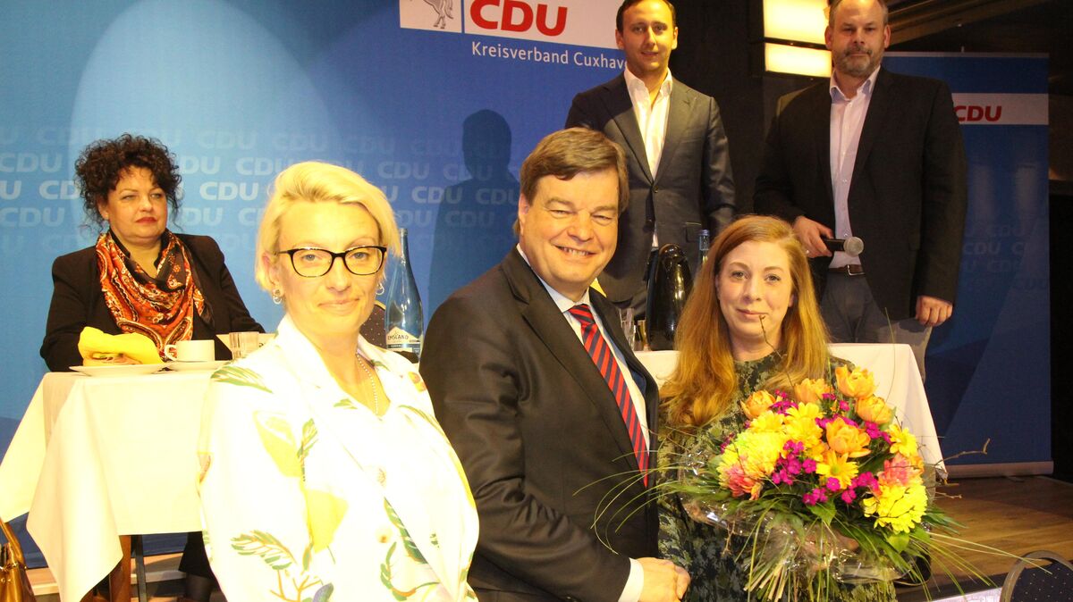 Blumen nach dem eindeutigen Wahlergebnis: Kreisvorsitzender Enak Ferlemann mit der 2. Vorsitzenden Julia Grebe (l.) und Schriftführerin Saskia Brandt, die ebenfalls im Amt bestätigt wurden. Oben das Präsidium mit Sylke von Oehsen, Felix Diekmann-Lange und Jörg-Andreas Sagemühl. Foto: Reese-Winne