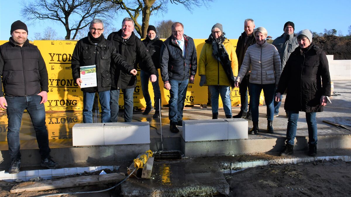 Lamstedts Bürgermeister Manfred Knust (6.v.r.) warf gemeinsam mit Vertretern der Verwaltung und der Nindorfer Vereine symbolisch die Schlüssel der abgerissenen "Ohle Dörpschool" in den Grundstein des neuen Gebäudes, das zentraler Treffpunkt für Vereine, Verbände, Feiern und Aktivitäten werden soll. Foto: Schröder