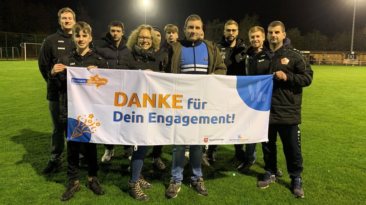 Juliane Schattauer (Mitte) vom KSB Cuxhaven und Torben von Thaden auf dem Spielfeld umrahmt von Spielern der Mannschaft der SpVgg BISON. Foto: SpVgg BISON