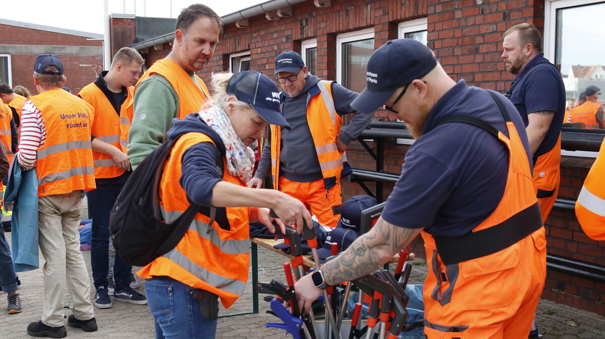 Start um 9 Uhr morgens: Auf dem NPorts-Gelände am Schleusenpriel werden Werkzeuge an die Müllsammler ausgegeben. Kurz darauf schwärmten Helferinnen und Helfer ins gesamte Hafengebiet aus. Foto: Koppe