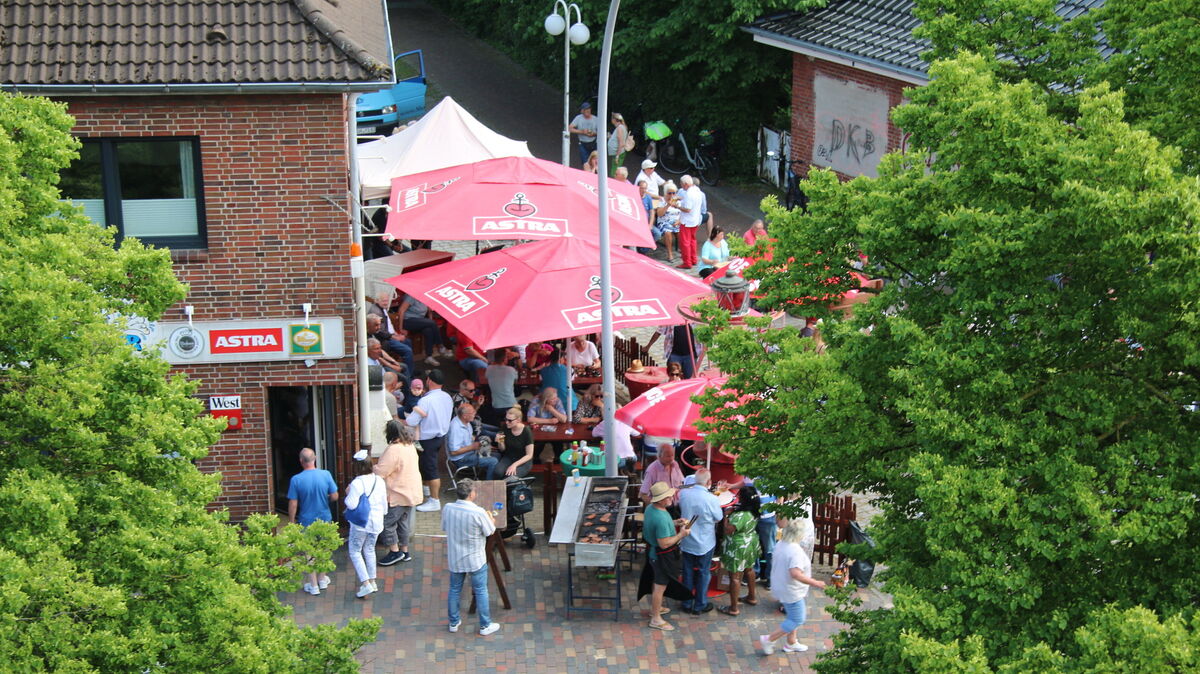Fröhliches Treiben beim Pfingstfest: Unter strahlendem Himmel versammeln sich Besucher vor der Traditionskneipe „Käpt’n Alexander“ in Cuxhaven, um bei Shanty-Klängen und sommerlichen Temperaturen die maritime Stimmung zu genießen. Foto: Potschka