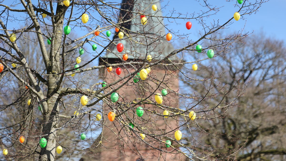 Große Ostereier hängen an einem Baum vor dem Lüdingworther Bauerndom. Foto: Lütt