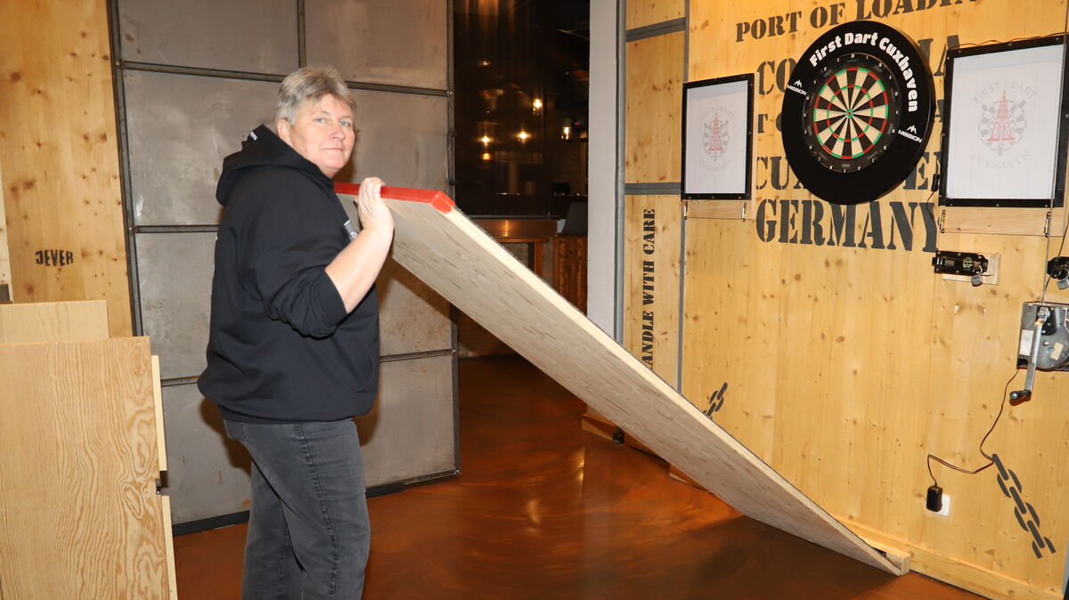 Christine Baack verwandelt den "Frachtraum" im "Unikat" mit wenigen Handgriffen in ein echtes Darts-Domizil. Sie wurde 1994 Cuxhavener Stadtmeisterin. Foto: Witthohn